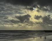 Lyme Regis Beach and Cobb at the bottom of the tide, under a moody sky